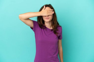 Mavi arka planda, gözleri elle kaplanmış beyaz bir kadın. Bir şey görmek istemiyorum.