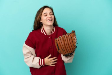 Beyzbol oynayan beyaz bir kadın mavi arka planda soyutlanmış, gülümsüyor.