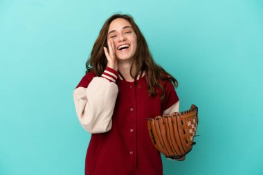 Beyzbol oynayan beyaz bir kadın mavi arka planda izole edilmiş ve ağzı açık bağırıyor.