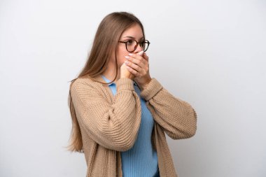 Genç Litvanyalı bir kadın beyaz arka planda izole edilmiş ağzını kapatıyor ve yan tarafa bakıyor.