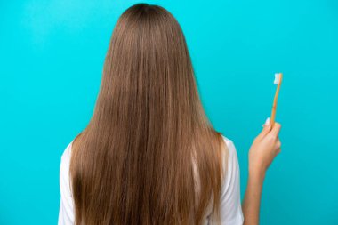 Genç Litvanyalı kadın arka planda dişlerini fırçalıyor.