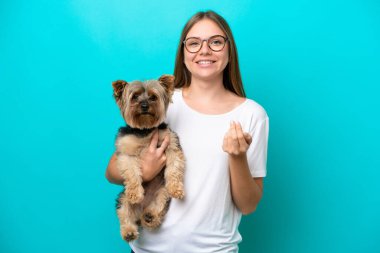 Genç Litvanyalı bir kadın mavi arka planda bir köpek tutuyor ve bizimle gelmesi için davet ediyor. Gelmene sevindim.