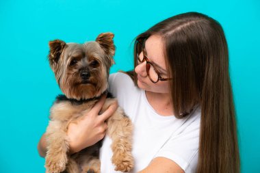 Mavi arka planda köpeği tutan Litvanyalı genç bir kadın.