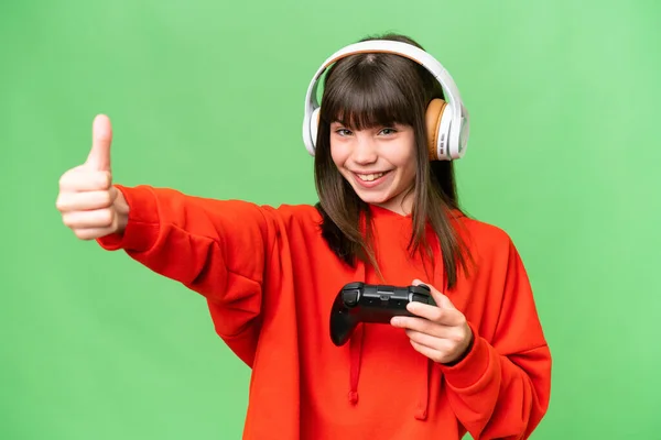 Malá Kavkazská Dívka Hraje Ovladačem Videohry Izolovaném Pozadí Dává Palce — Stock fotografie