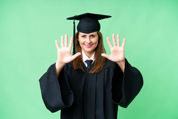 Middle age university graduate woman over isolated background counting ten with fingers