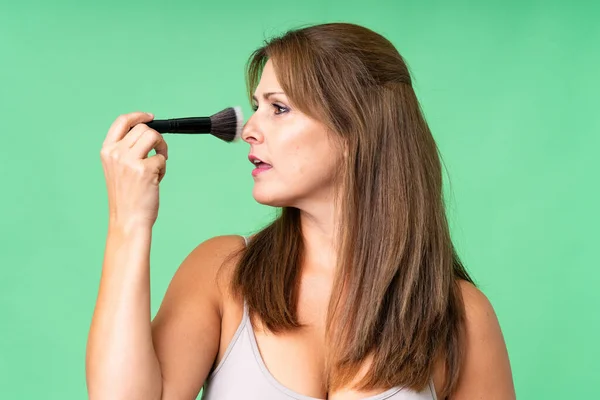 Medelålders Kvinna Över Isolerad Bakgrund Håller Makeup Borste — Stockfoto