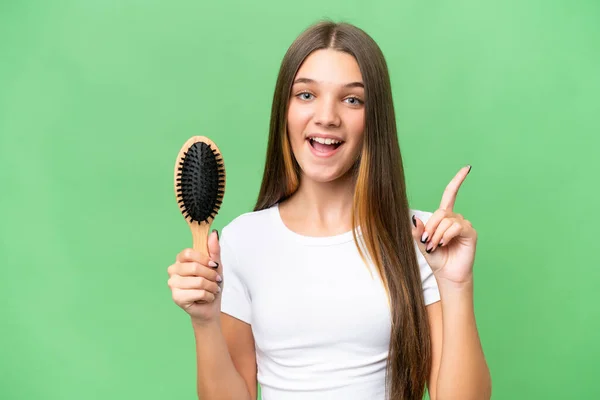Teenager caucasian girl with hair comb over isolated background pointing up a great idea