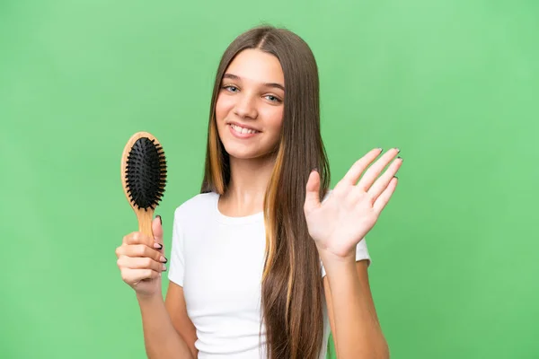Teenager caucasian girl with hair comb over isolated background saluting with hand with happy expression