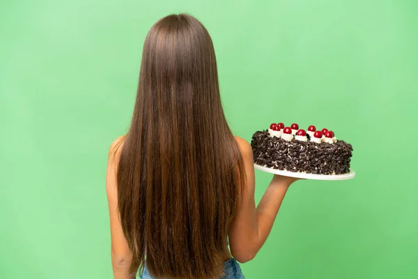 ティーンCaucasian女の子保持誕生日ケーキ上の隔離された背景でバック位置 — ストック写真