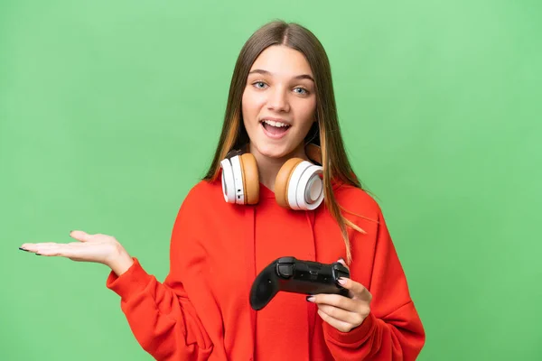 青少年白种人女孩带着震惊的表情 在孤立的背景下玩电子游戏控制器 — 图库照片