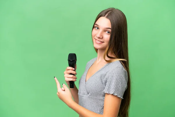 Genç Şarkıcı Kız Arka Planda Izole Edilmiş Bir Mikrofonu Kaldırıyor — Stok fotoğraf