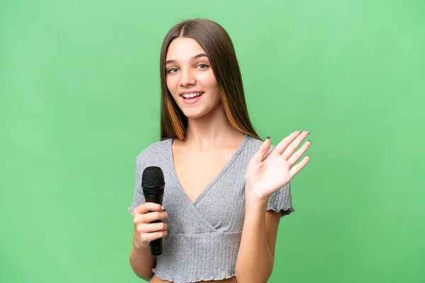 Chica Cantante Adolescente Recogiendo Micrófono Sobre Fondo Aislado Saludando Con — Foto de Stock
