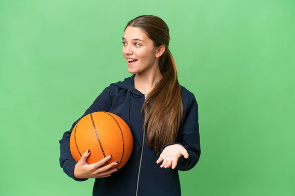 ティーンCaucasian女の子遊びますバスケットボール上の隔離された背景とともに驚きの表現とともに見ます側 — ストック写真