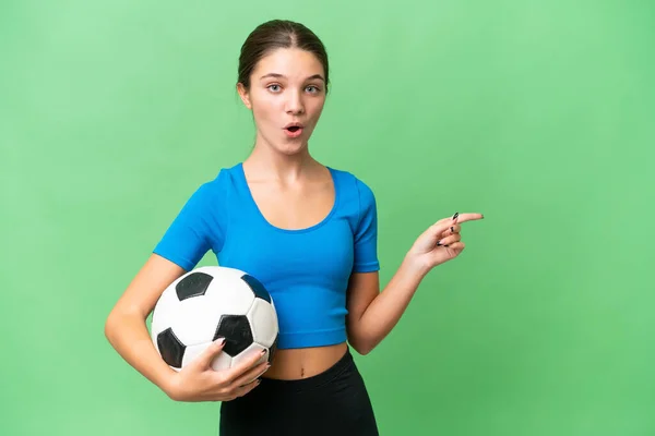 Adolescente Caucasiano Menina Jogando Futebol Sobre Fundo Isolado Surpreendido Apontando — Fotografia de Stock