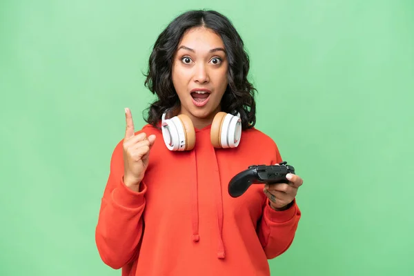 stock image Young Argentinian woman playing with a video game controller over isolated background intending to realizes the solution while lifting a finger up