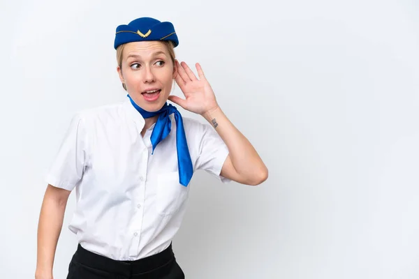 耳に手を置くことによって何かを聞いて白い背景に隔離された飛行機ブロンドスチュワーデス女性 — ストック写真