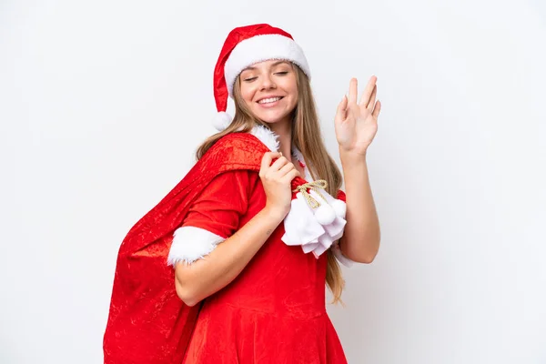 年轻的高加索女人打扮成妈妈诺埃尔 手里拿着白色背景的圣诞礼物袋 满面春风 手牵着手致意 — 图库照片