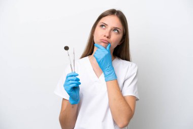 Dentist woman holding tools isolated on white background having doubts