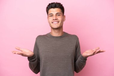 Pembe arka planda izole edilmiş genç beyaz adamın şüpheleri var.