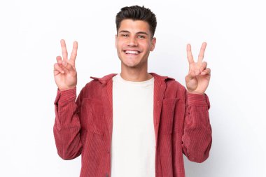 Young caucasian man isolated on white background showing victory sign with both hands