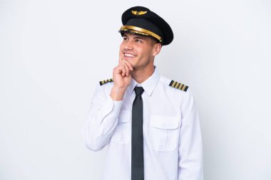 Airplane caucasian pilot isolated on white background thinking an idea while looking up