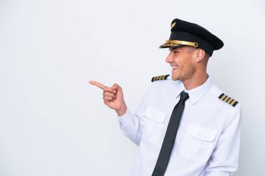 Airplane caucasian pilot isolated on white background pointing finger to the side and presenting a product