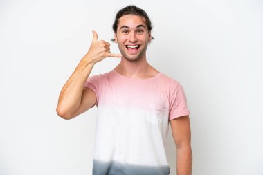 Beyaz arka planda izole edilmiş beyaz, yakışıklı bir adam telefon jesti yapıyor. Bana geri dönüş işareti ver.