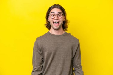 Caucasian handsome man isolated on yellow background with surprise facial expression