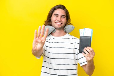 Şişme yastıklı yakışıklı adam mutlu ve parmaklarıyla dörde kadar sayıyor.