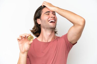 Beyaz arka planda izole edilmiş Bitcoin tutan genç yakışıklı bir adam bir şey fark etti ve çözüme niyetlendi.