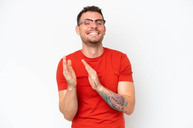 Beyaz arka planda izole edilmiş beyaz tenli yakışıklı bir adam bir konferanstan sonra alkışlıyor.