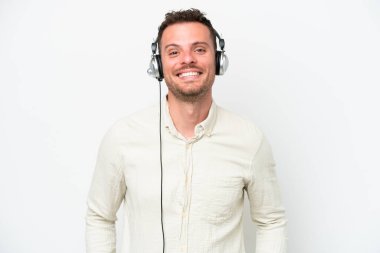 Beyaz arka planda izole edilmiş kulaklıkla çalışan beyaz pazarlamacı beyaz adam gülüyor.