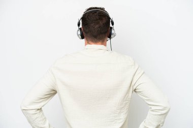 Beyaz arka planda izole edilmiş bir kulaklıkla çalışan beyaz pazarlamacı beyaz adam.