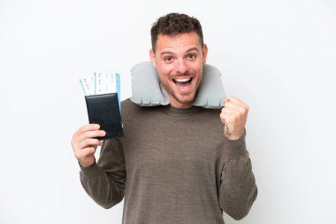 Beyaz arka planda izole edilmiş pasaport taşıyan genç beyaz adam galibiyeti kutluyor.