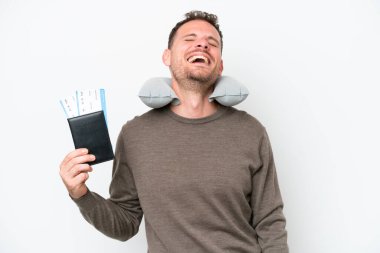Young caucasian man holding a passport isolated on white background laughing