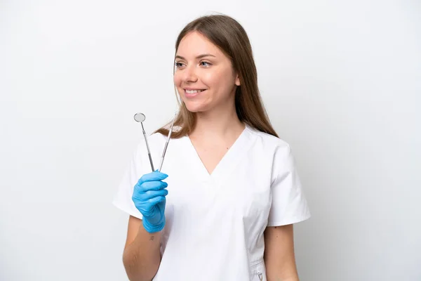 歯医者の女性側を見て白い背景に隔離されたツールを保持し — ストック写真