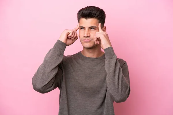 stock image Young caucasian man isolated on pink background having doubts and thinking