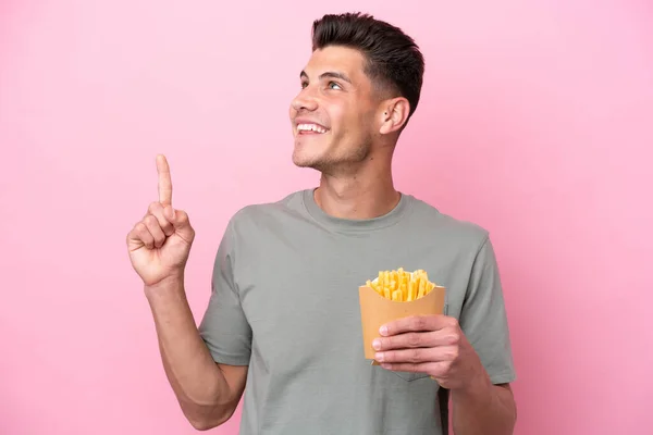 Jonge Blanke Man Met Gebakken Chips Geïsoleerd Roze Achtergrond Wijzend — Stockfoto