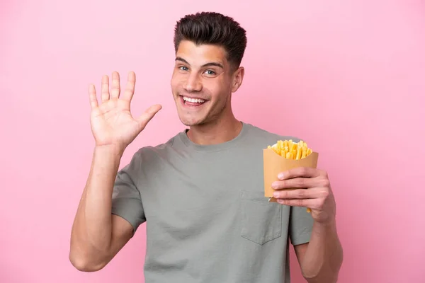 Jonge Blanke Man Met Gebakken Chips Geïsoleerd Roze Achtergrond Salueren — Stockfoto
