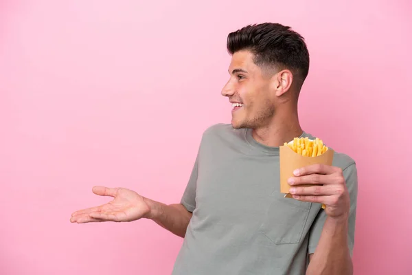 Jonge Kaukasische Man Met Gebakken Chips Geïsoleerd Roze Achtergrond Met — Stockfoto