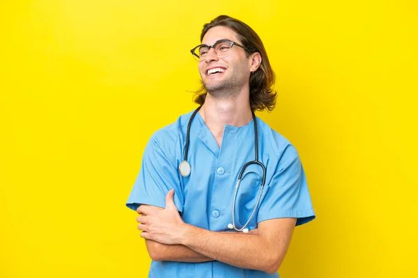 年轻的外科医生高加索人在黄种人的背景上孤立无援 面带微笑 — 图库照片