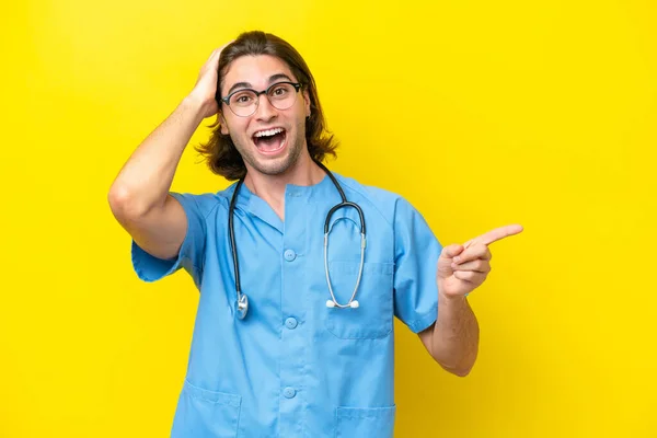 Young Surgeon Caucasian Man Isolated Yellow Background Surprised Pointing Finger — Stock Photo, Image