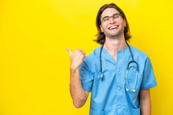 Young Surgeon Caucasian Man Isolated Yellow Background Pointing Side Present — Stock Photo, Image
