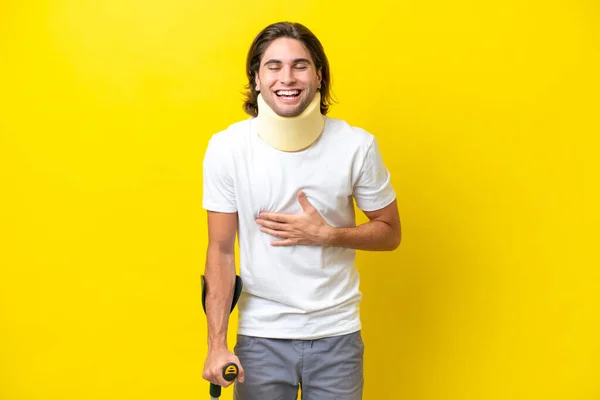 Junger Gutaussehender Mann Mit Nackenstütze Und Krücken Auf Gelbem Hintergrund — Stockfoto