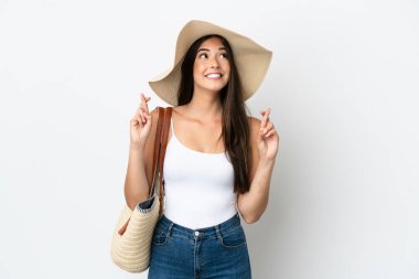 Pamela 'nın yanındaki genç Brezilyalı kadın beyaz arka planda izole edilmiş bir plaj çantası tutuyor.