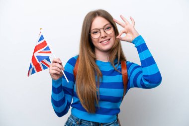 Beyaz arka planda izole edilmiş bir Birleşik Krallık bayrağı tutan beyaz kadın parmaklarıyla işaret veriyor.