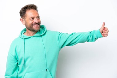 Beyaz arka planda izole edilmiş orta yaşlı beyaz bir adam baş parmak hareketi yapıyor.