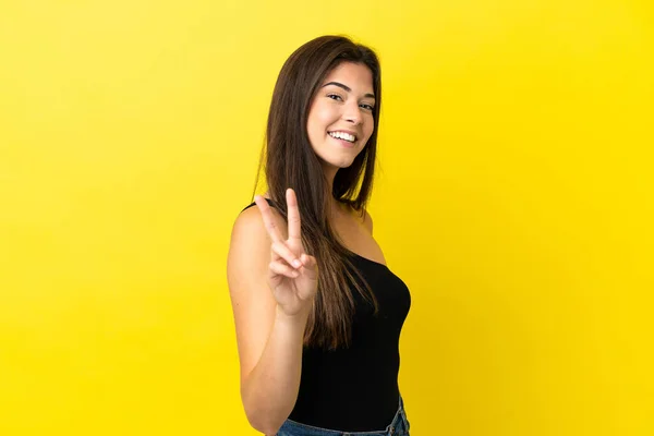 Jovem Brasileira Isolada Fundo Amarelo Sorrindo Mostrando Sinal Vitória — Fotografia de Stock