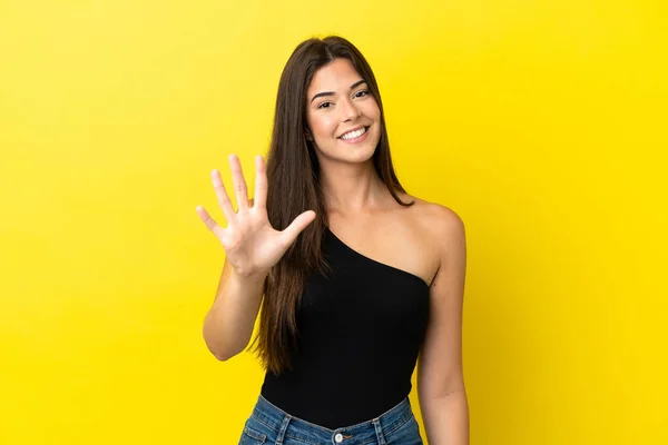 Sarı Arka Planda Izole Edilmiş Genç Brezilyalı Kadın Parmaklarıyla Beşi — Stok fotoğraf