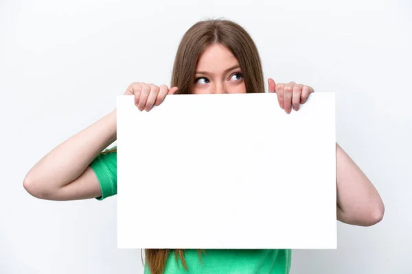 年轻的高加索女人 背景是白色的 手里拿着一块空布告 藏在布告后面 — 图库照片